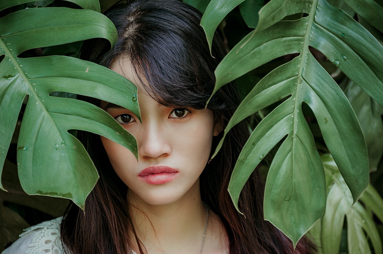 Cambodian woman standing between green leafed plant